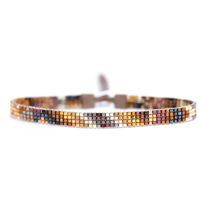 The JULIE ROFMAN - ORO BRACELET by JULIE ROFMAN JEWELRY features a handwoven design with small, vibrant square beads in shades of orange, yellow, pink, and black. This stylish bracelet is finished with a loop closure on a white background.
