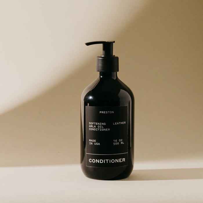 A black pump bottle labeled "PRESTON - CONDITIONER" by PRESTON (16 oz / 500 ml, Made in USA) sits on a beige background, highlighting its nourishing formula for aniline leather.