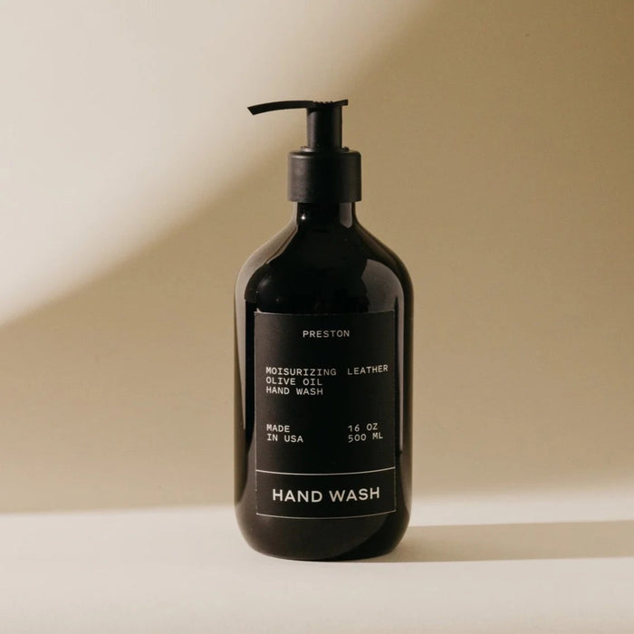 A dark pump bottle labeled "PRESTON - HAND WASH 16OZ" sits on a light surface with soft shadows. The label notes Preston's ultra-thick formula, moisturizing olive oil, Made in USA, 16 oz (500 ml).