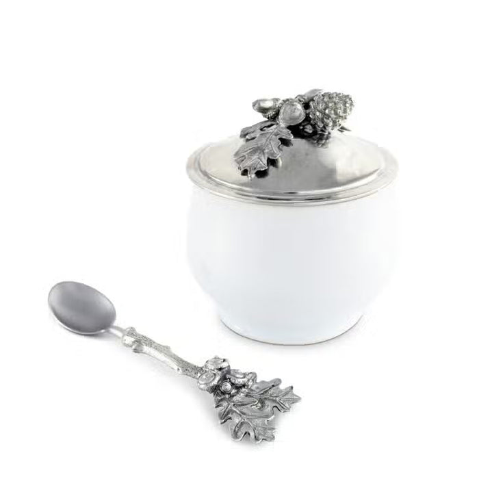 The VAGABOND HOUSE - ACORN OAK LEAF SUGAR BOWL is a white porcelain and pewter container with a silver lid, topped with detailed metal oak leaves and acorns—perfect for adding lodge style charm to your Antler Creamer Set.