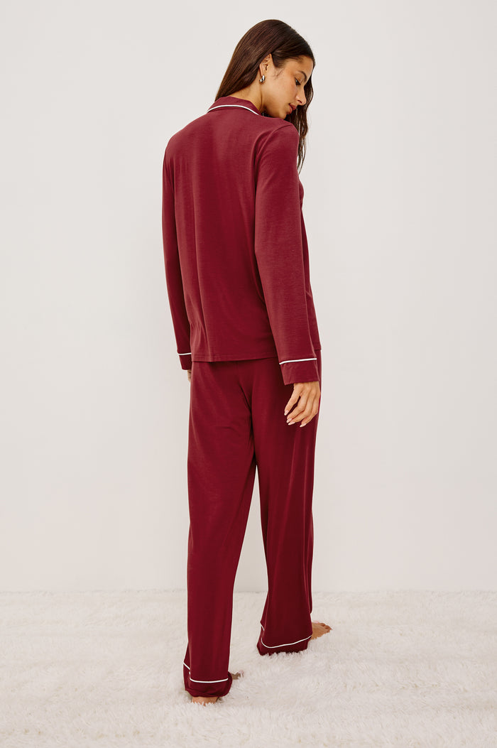 Varra Pajama Set in Jersey With Contrast Piping Button-Up Shirt With Notched Collar and Long Sleeves and Matching High-Waisted Pants With Adjustable Waist Drawstring Ties in Loose Fit in Cabernet Colorway - Full Body Back View Featured on Model