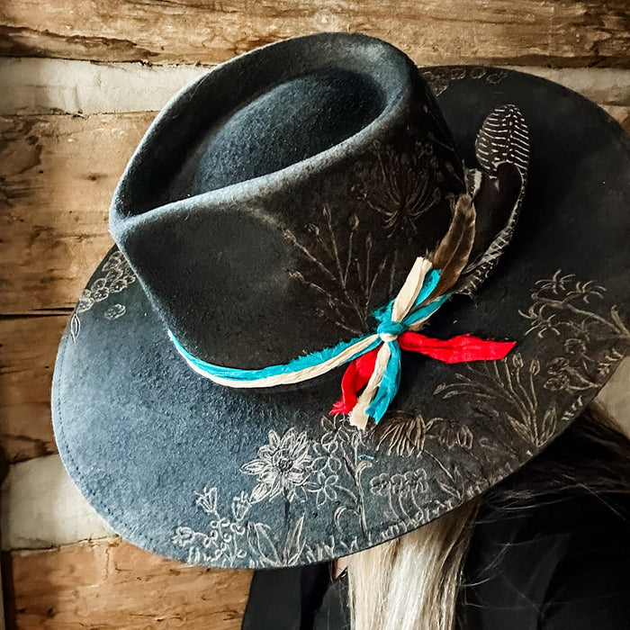 Black hat with floral design and feather
