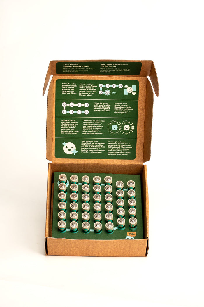 An open box of Better Battery Cos AA Alkaline Batteries displays rows of batteries. The inside lid has a green background with white text highlighting the Zero Waste Batteries initiative. Join the recycling program to enjoy carbon-neutral alkaline batteries benefits.