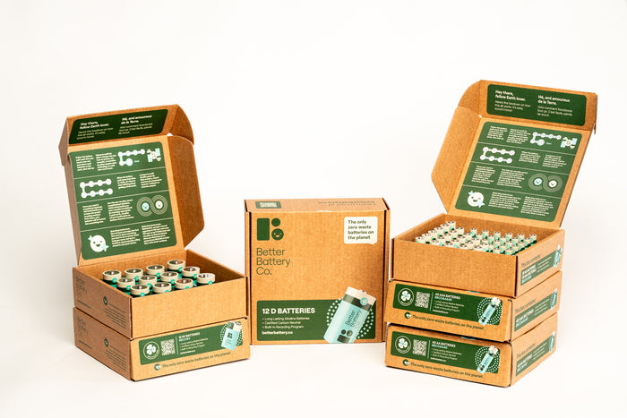 Four open boxes of Better Battery Cos AA Alkaline Batteries are displayed against a white background. Each box features green labels with text and icons, highlighting their carbon-neutral status and commitment to recycling programs, making them an eco-friendly choice.