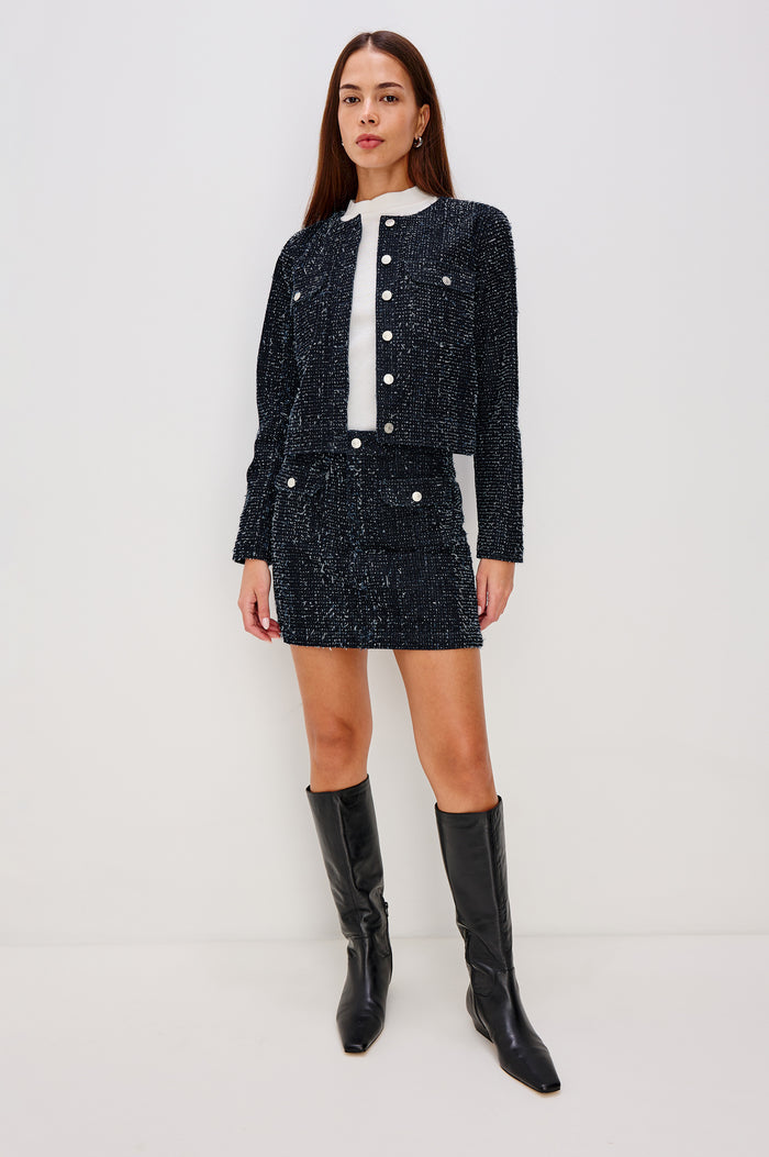 Abbot Mini Skirt in Rigid Denim With Tweed Texture With High-Rise High-Waisted Fit, Front Button Flap Pockets, and Front Zip Closure - Lower Body Front Close Up View Featured on Model