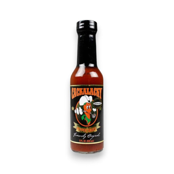 A 5 fl oz (150 ml) bottle of CACKALACKY - JACK PEPPER SAUCE GOLD by CACKALACKY, featuring a black label with a cartoon pepper in a chef’s hat, plus white, orange, and green text. This is an all-natural hot sauce.