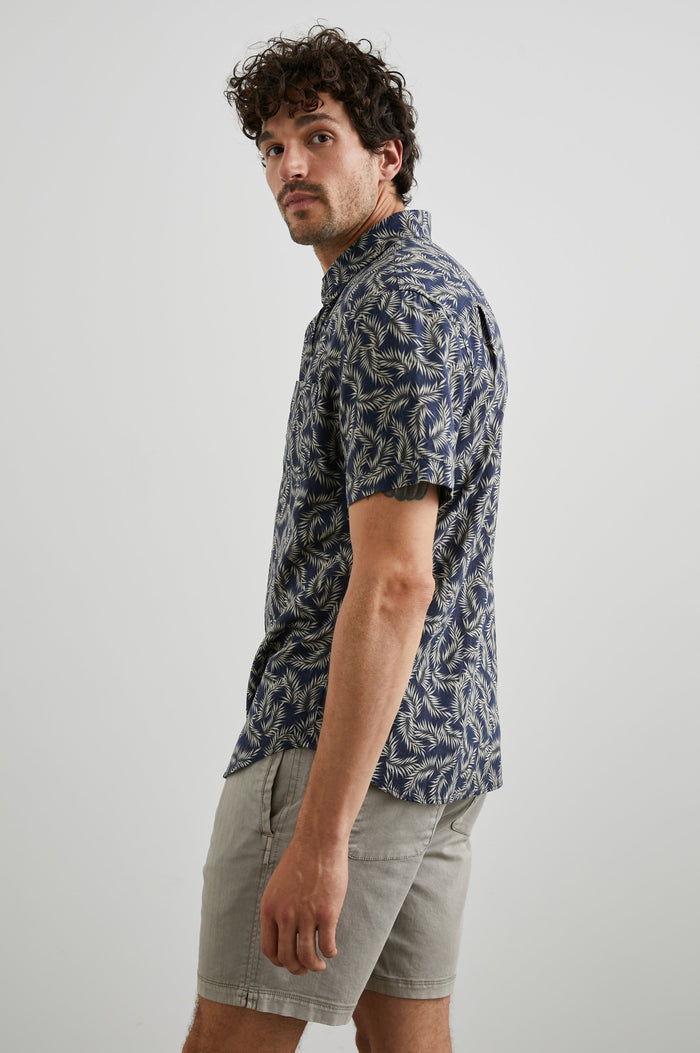 Carson Short Sleeve Button Up with a Chest Patch Pocket in Palm American Navy Colorway, Tan Fronds on Navy - Side View Featured on Model