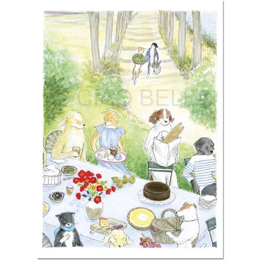 A group of animals and a person gather outdoors around food, cakes, flowers, and the CIAO BELLA - LE MIDI CARD by CIAO BELLA. Two animals carrying groceries approach the picnic along a tree-lined path.