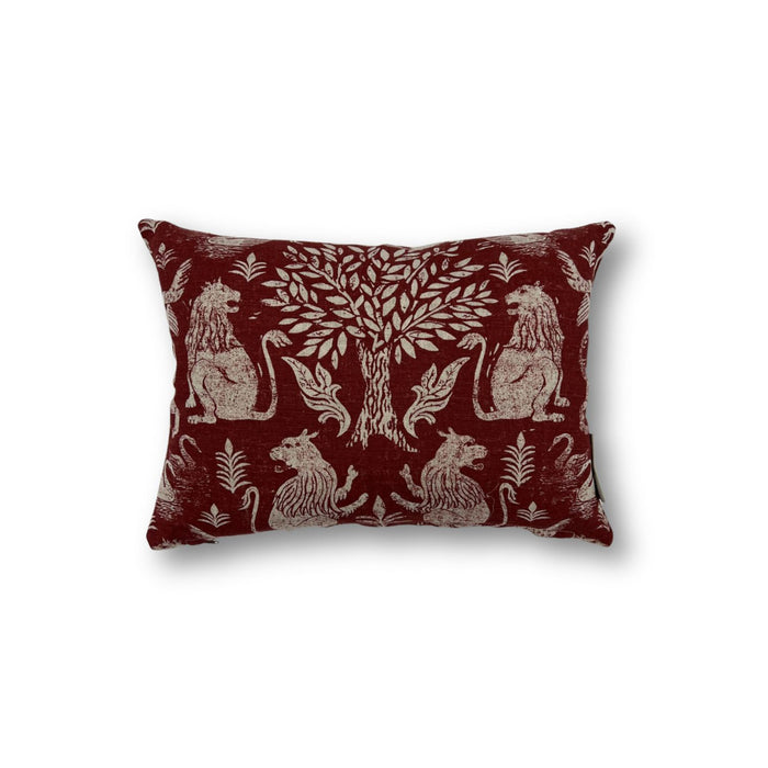 Rectangular throw pillow with a tree at center framed with symetrical lion figures, the back ground is a solid brick red, the motif is a natural linen color.