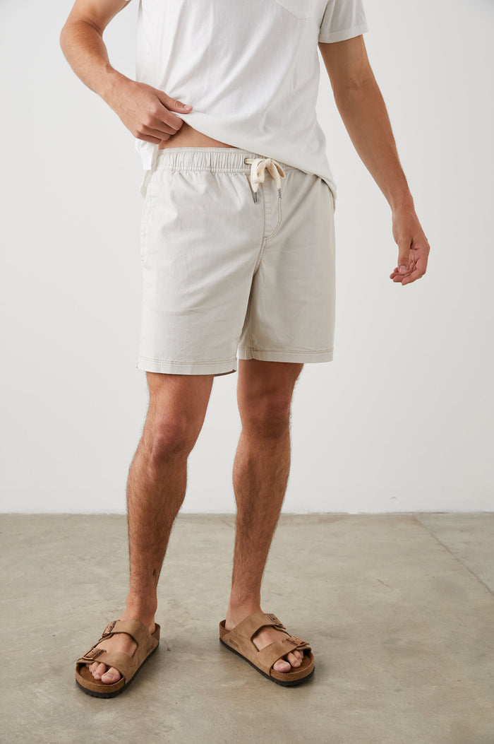 Cruz Shorts with a Drawstring Waist, Two Front Pockets, Two Back Button Flap Pockets in Natural Colorway - Front View Featured on Model