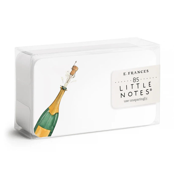 A clear box holds 85 E. FRANCES PAPER - FLYING CORK LITTLE NOTES—small, hand painted notecards from E. FRANCES PAPER, featuring a champagne bottle "flying cork" design. The label reads "E. Frances 85 Little Notes—use unsparingly.