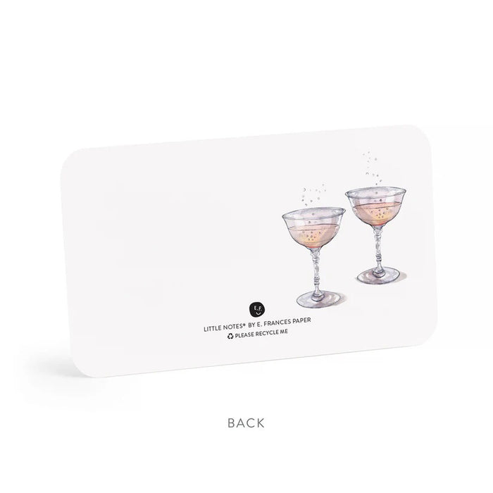 A clear box holds 85 E. FRANCES PAPER - FLYING CORK LITTLE NOTES—small, hand painted notecards from E. FRANCES PAPER, featuring a champagne bottle "flying cork" design. The label reads "E. Frances 85 Little Notes—use unsparingly.