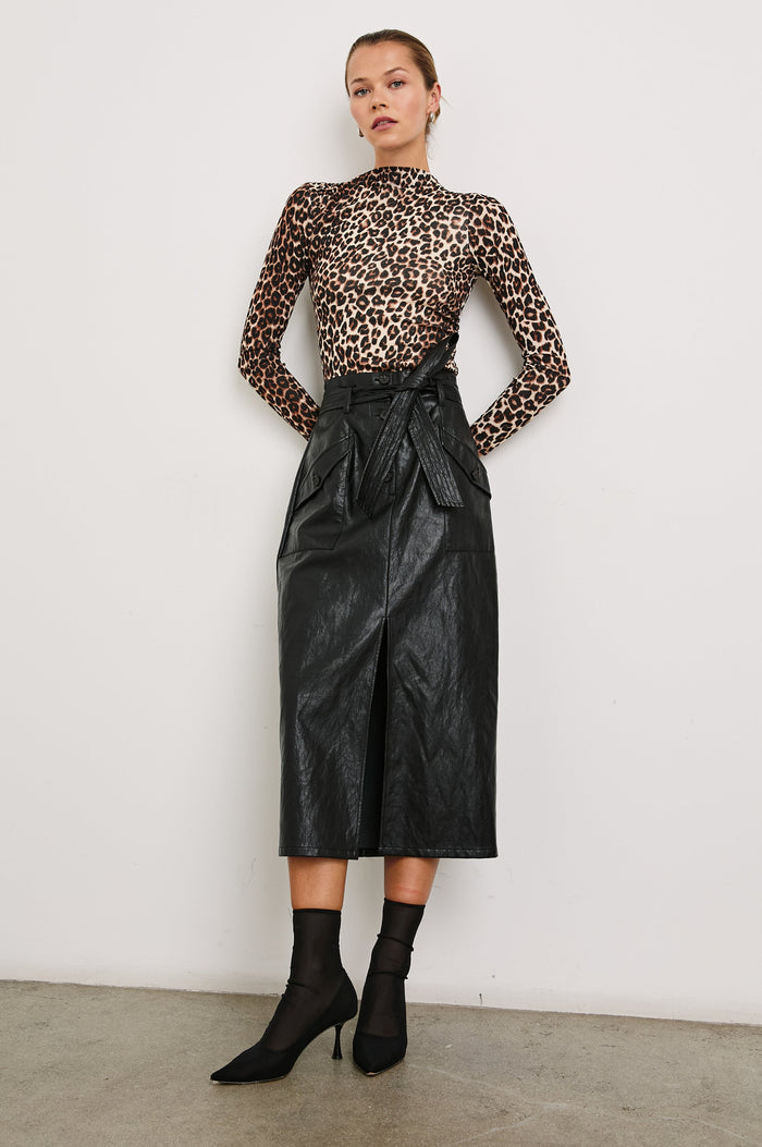 Edem Midi Skirt with a Tie Belt, a Center Slit, Four Button Closure at the Waist, Two Front Pockets Each Overlaid with a Button Flap Pocket and Two Back Welt Pockets in Black Colorway - Front Full Body View Featured on Model