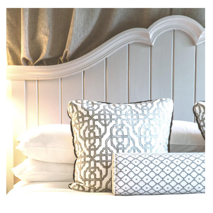 The FEARRINGTON HOUSE FEARRINGTON LIFESTYLE BEDDING COLLECTION - QUEEN LINEN EXPERIENCE features two white pillows, a crisp sheet set, and a textured blanket on a paneled wall, illuminated by soft natural light for an inviting, luxurious look.