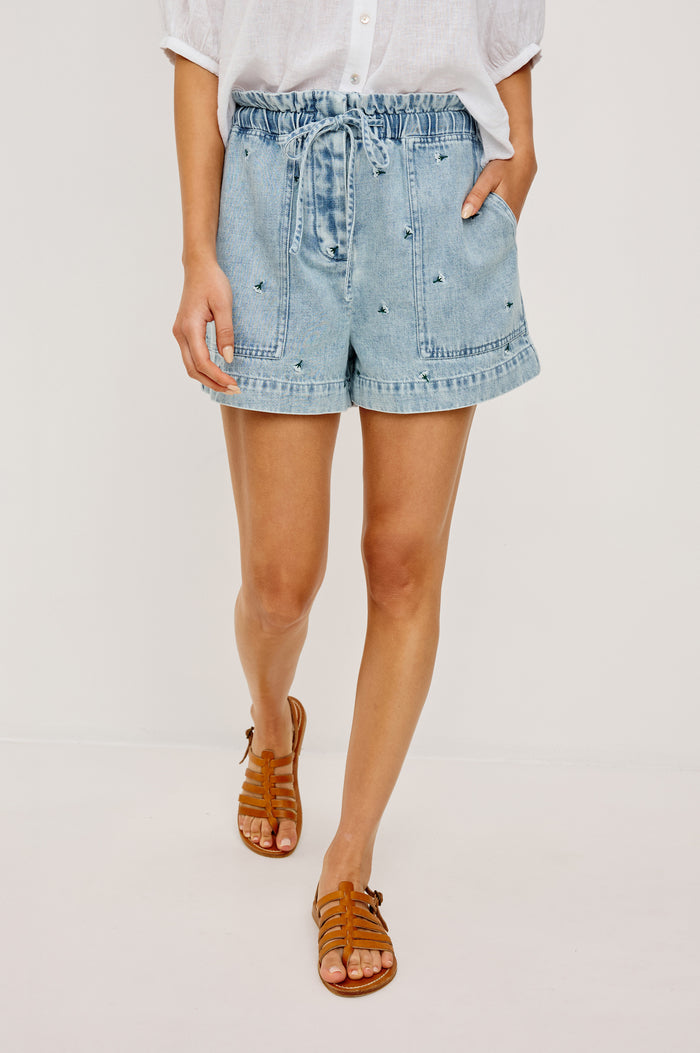 Foster Short in TENCEL™ Denim With High Drawstring Paperbag Waist With Adjustable Ties, Relaxed FIt, and Side and Back Pockets in Ivory Carnations Colorway - Lower Body Front View Featured on Model