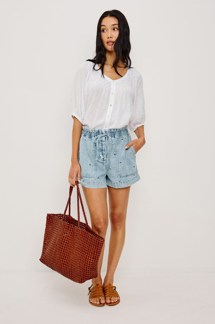 Foster Short in TENCEL™ Denim With High Drawstring Paperbag Waist With Adjustable Ties, Relaxed FIt, and Side and Back Pockets in Ivory Carnations Colorway - Lower Body Front View Featured on Model