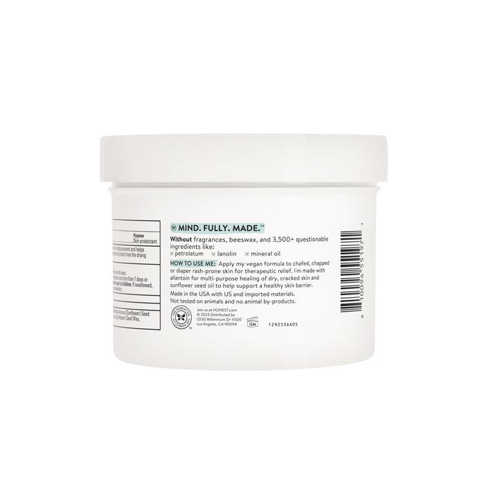 A white jar labeled with details of The Honest Companys Healing Head to Toe Ointment - Value Size, featuring allantoin and lanolin for healthy-looking skin. Free from fragrances and unnecessary ingredients, the label includes usage instructions and ingredient notes highlighting its mindful creation.