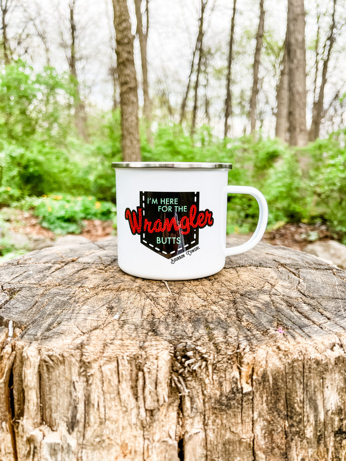 White mug with text on a tree stump.
