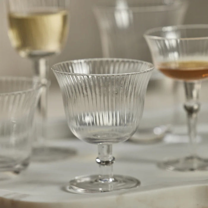 The ZODAX JULIEN OPTIC COCKTAIL GLASS features a clear fluted bowl, short stem, and circular base, shown against a white background—ideal as an elegant small drinking glass for special occasions.