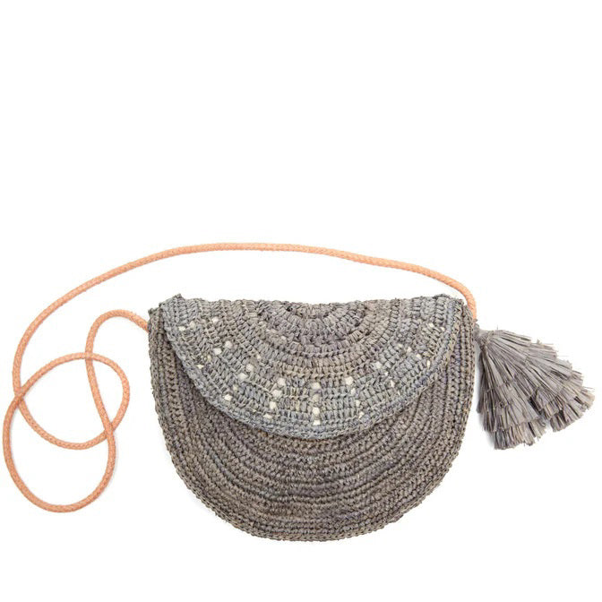 The MAR Y SOL LILA CROSSBODY by MAR Y SOL is a round gray crocheted raffia bag featuring a pink strap and a large gray tassel, shown against a white background.