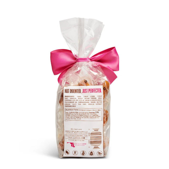 A clear bag of Mouth Party Sea Salt Caramels, tied with a bright pink bow and labeled "MOUTH PARTY - SEA SALT CARAMEL BAG.