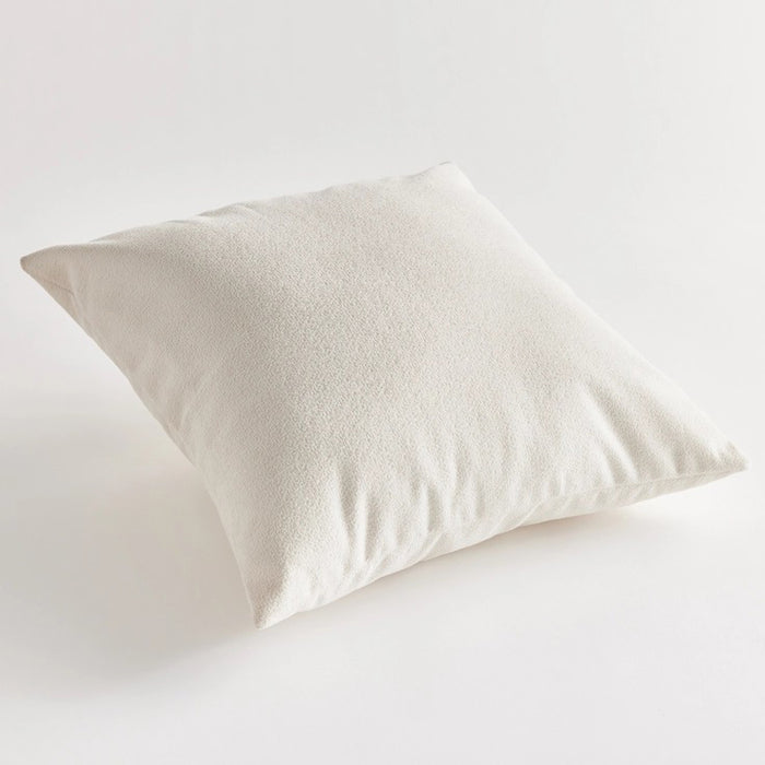 Against a plain white background, the NAPA HOME AND GARDEN - COOPER SQUARE INDOOR-OUTDOOR PILLOW 20", with its soft and fluffy Jacquard texture, appears smooth and slightly plump, ideal for resting or sleeping in any weather-resistant setting.