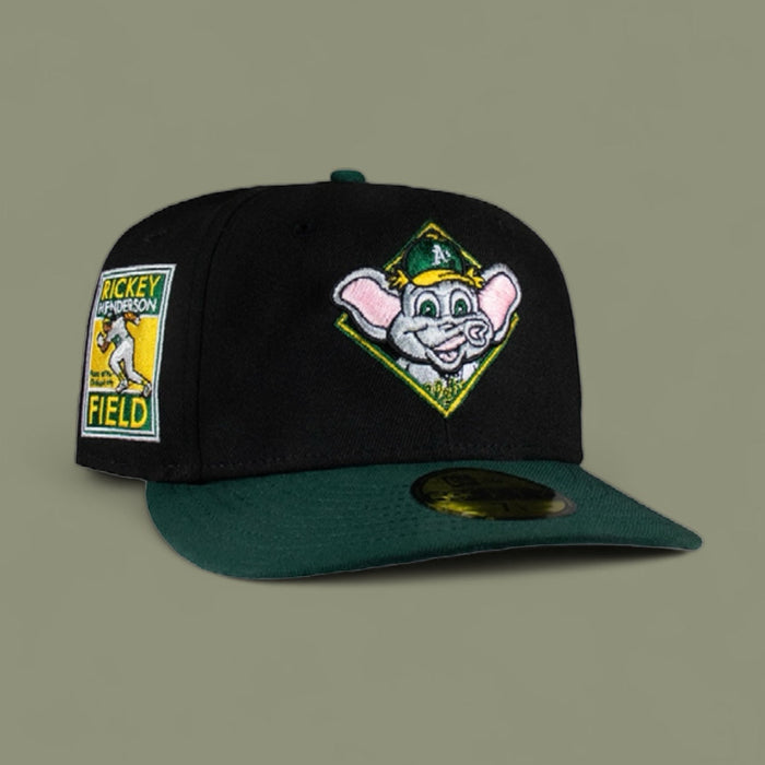 A black and green fitted baseball cap with a cartoon character logo on the front.