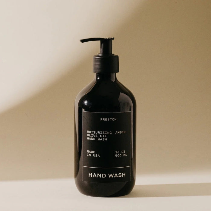A dark pump bottle labeled "PRESTON - HAND WASH 16OZ" sits on a light surface with soft shadows. The label notes Preston's ultra-thick formula, moisturizing olive oil, Made in USA, 16 oz (500 ml).