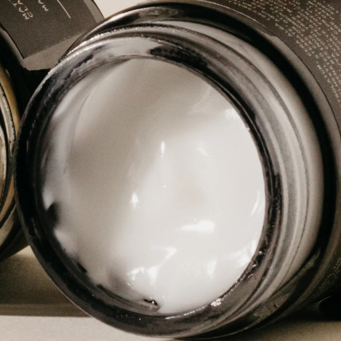 A black PRESTON - TEXTURED LOTION jar rests on a light surface, its shadow softly cast against a beige backdrop—ideal for anyone wanting a matte finish and light hold from the trusted PRESTON brand.