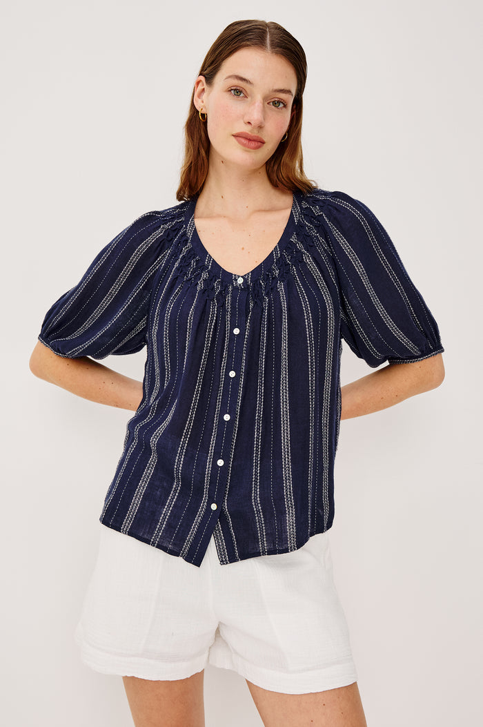 Rix Top in Linen With Scoop Neckline Relaxed Fit Smocked Yoke Elbow-Length Raglan Sleeves and Front Buttons in Marina Stripe Colorway - Upper Body Front View Featured on Model