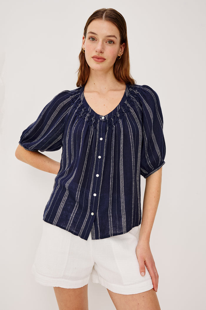 Rix Top in Linen With Scoop Neckline Relaxed Fit Smocked Yoke Elbow-Length Raglan Sleeves and Front Buttons in Marina Stripe Colorway - Upper Body Front View Featured on Model