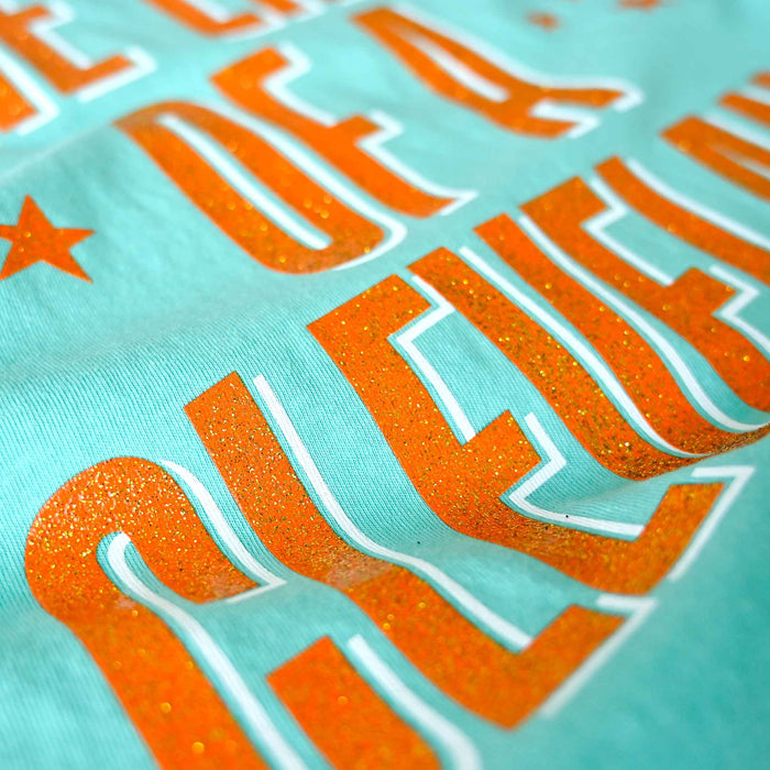 Close-up of orange text on a turquoise background