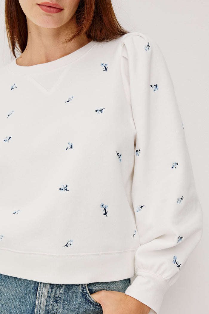 Tiffany Crewneck Sweatshirt in French Terry With Contrast Floral Embroidery, Long Puff Sleeves With Fitted Cuffs, and Ribbed Trim in Blue Iris Colorway - Upper Body Front Close Up View Featured on Model