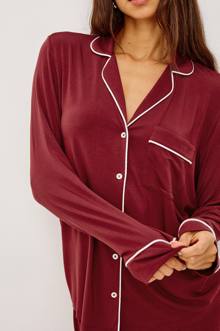 Varra Pajama Set in Jersey With Contrast Piping Button-Up Shirt With Notched Collar and Long Sleeves and Matching High-Waisted Pants With Adjustable Waist Drawstring Ties in Loose Fit in Cabernet Colorway - Upper Body Close Up View Featured on Model