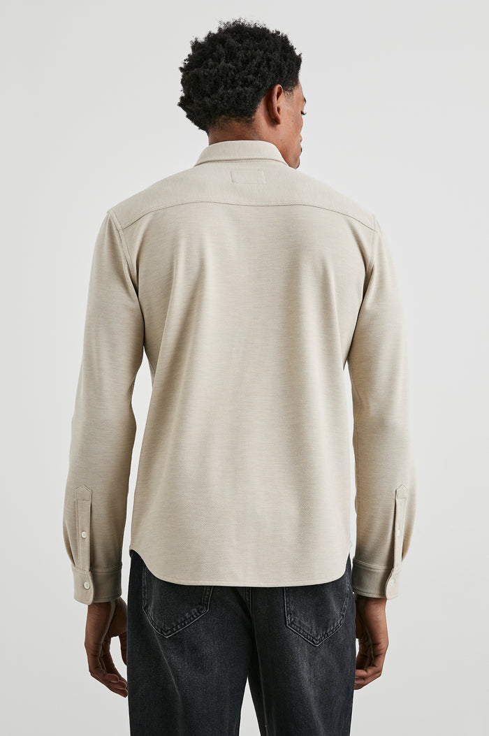 Vincent long sleeve shirt combines comfort of a knit with a buttoned classic collar. Front view of model feautured.