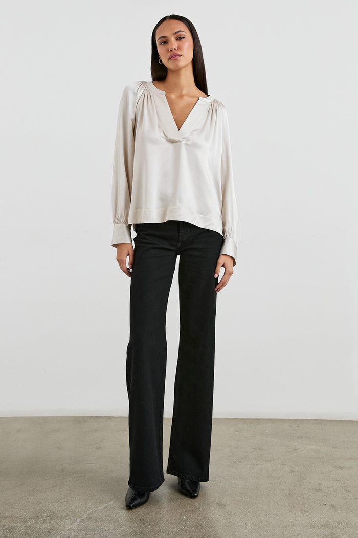 Wynna Long-Sleeve Top with a Deep V Neck and Ruching above the Cuffs and at the Neckline in Ivory Colorway - Front View Featured on Model